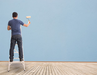 Man Painting On Blue Wall,Concept And Ideas