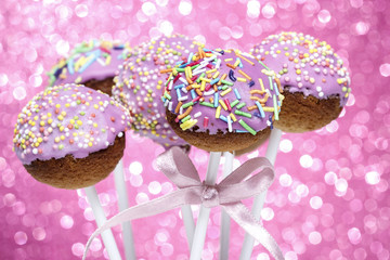 Obraz na płótnie Canvas Pink cake pops decorated with colorful sprinkles