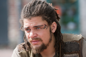 Portrait young rebel with dreadlocks and tattoos