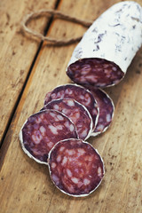 traditional sliced meat sausage salami on wooden board