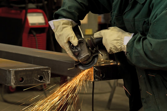 factory worker using electric grinder