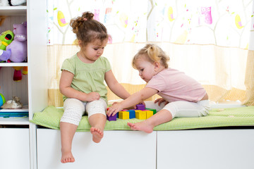 children sisters play together indoors