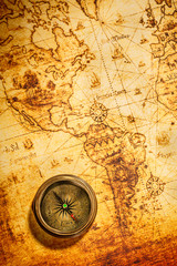 Obraz na płótnie Canvas Vintage Kompas leży na mapie świata starożytnego.