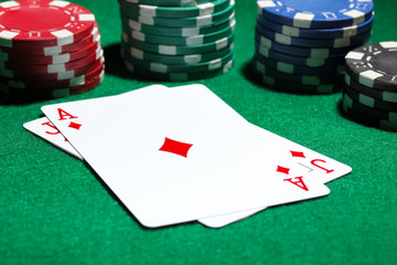 Cards and chips for poker on green table