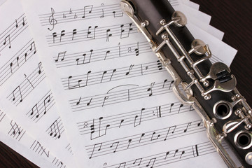 Musical notes and clarinet on wooden table