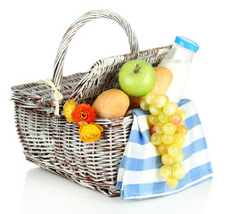 Picnic basket with fruits and bottle of milk, isolated on white