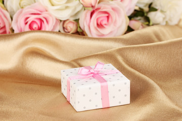 Beautiful gift on flowers background