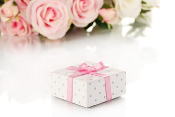 Beautiful gift on flowers background isolated on white
