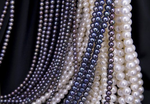 Black and white pearl beads on the black background