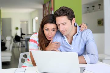 Couple at home sitting in front of laptop
