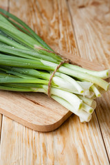 fresh green onions on a wooden surface