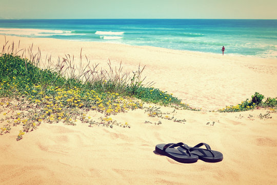 Slippers on the background of the beautiful beach and the sea. I