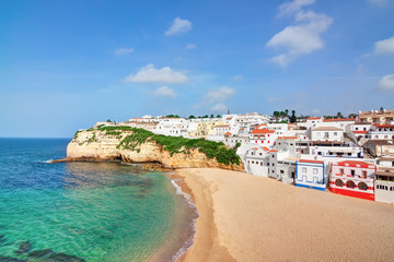 Portuguese villa in Carvoeiro beach with clear blue sea. In the - obrazy, fototapety, plakaty