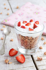 Muesli with cream and strawberry on wooden table