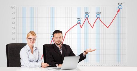 Businessman and businesswoman calculating stock market with risi