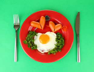Sausages in form of hearts, scrambled eggs and parsley,