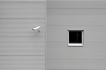 Security camera on industrial building with window