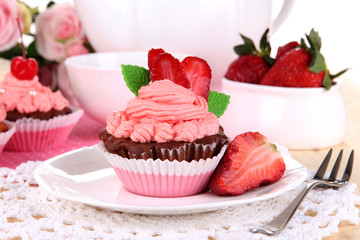 Beautiful strawberry cupcakes on dining table close-up