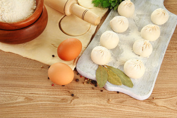 Raw dumplings, ingredients and dough, on wooden table