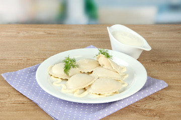 Tasty dumplings on plate, on wooden table