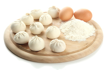 Raw khinkali on wooden desk, isolated on white