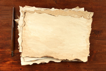 Old paper and ink pen on wooden background