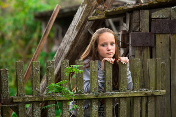 Teengirl standing near vintage rural fence.