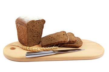 Fresh bread with ears and a knife of wheat on the wooden cutting