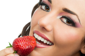 Attractive girl eating strawberry.