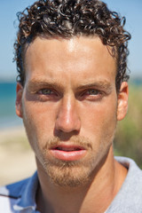 Obraz premium Portrait of a handsome young mediterranean man with curly hair