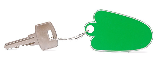 A green blank key tag with silver key on white background