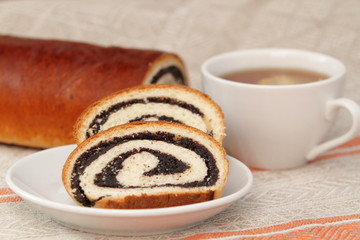 Fresh roll with poppy and tea
