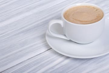 Coffee with cream on a white wooden table
