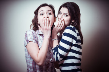 two young woman gossiping