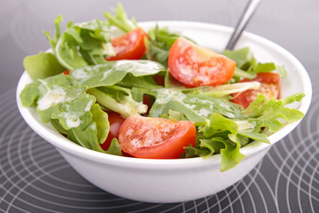 bowl of tomato salad with lettuce and sauce