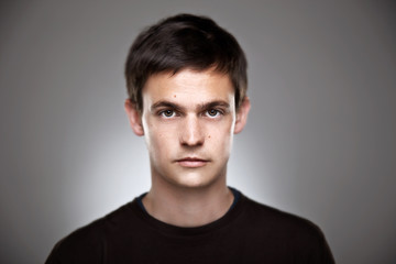 Portrait of a normal boy on a grey background