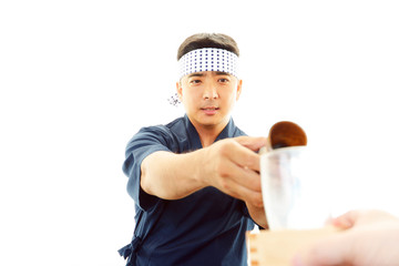 日本酒の瓶を持つ笑顔の寿司職人