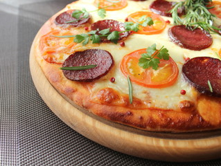 Pizza with tomato, salami and herbs