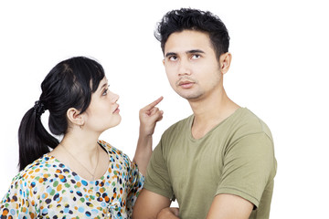 Angry girlfriend pointing at boyfriend on white