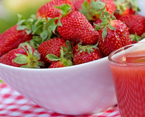 A full bowl of strawberries and strawberry juice