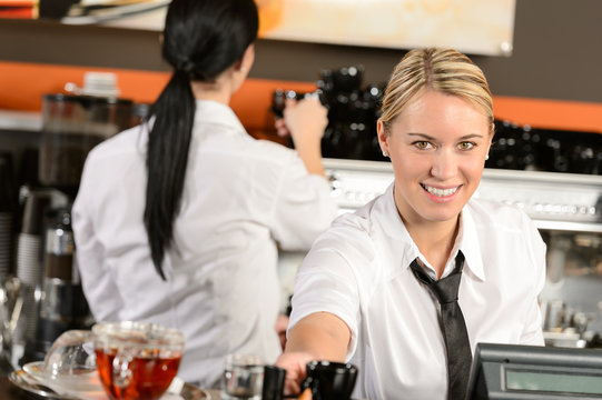Young waitress cashier giving coffee in cafe