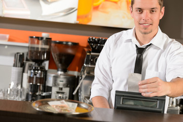 Fototapeta na wymiar Handsome smiling male waiter giving receipt CZK