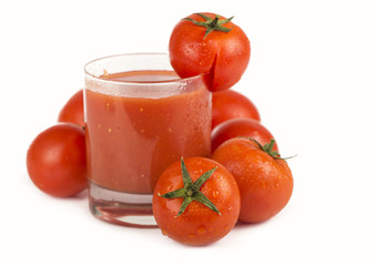 Isolated image of a glass of tomato juice and tomatoes on white