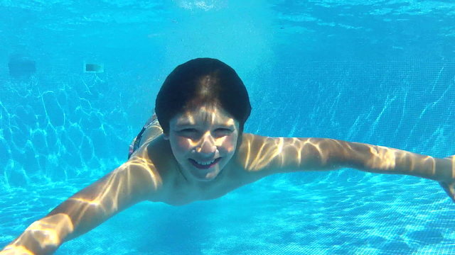 Boy Jumps Into Swimming Pool Then Swims Underwater To Camera