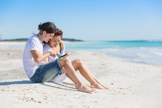 Young Couple at Seaside with Digital Tablet
