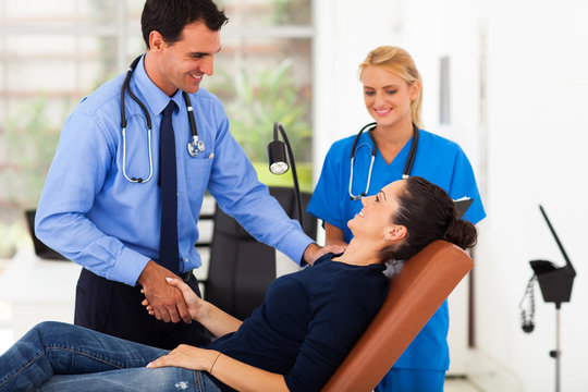 doctor congratulating female patient for her successful recovery