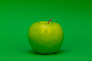 a plastic green apple on a green background