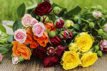 Fabulous bouquet of colorful roses on wooden tray in fresh sprin