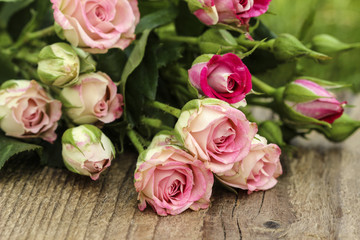Fabulous bouquet of colorful roses on wooden tray in fresh sprin