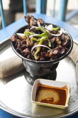 a serving of meat and injara in an ethiopian restaurant
